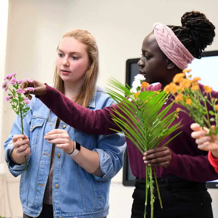 two students making flower arrangements