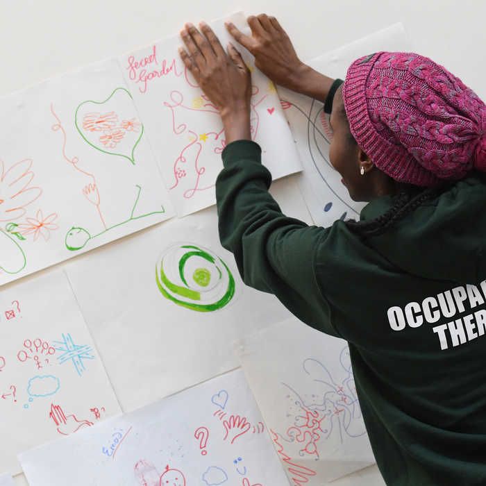 An occupational therapy students hanging up a poster