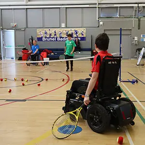 boy-in-wheelchair-playing-tennis-in-sports-hall