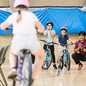 children-cycling-in-sports-hall