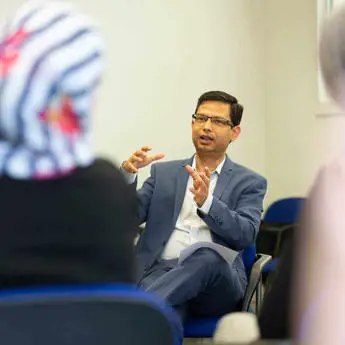 male lecturer talking to students in a classroom