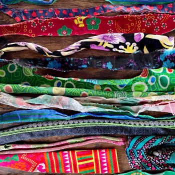 Assortment of many colourful pieces of cloth on wood