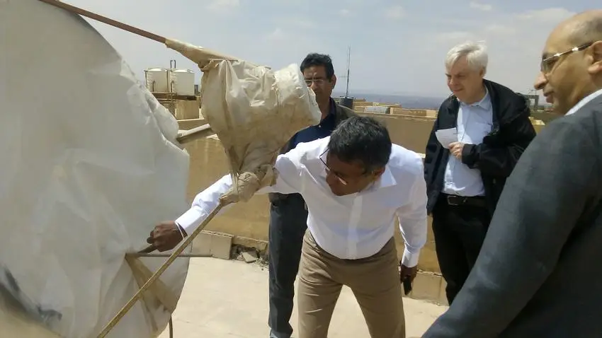The research team inspects the paraboloidal dish concentrator