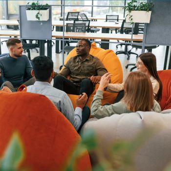 A group of people sitting on bean bag chairs and talking