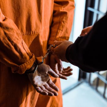 A police officer removing handcuffs from a prison inmate