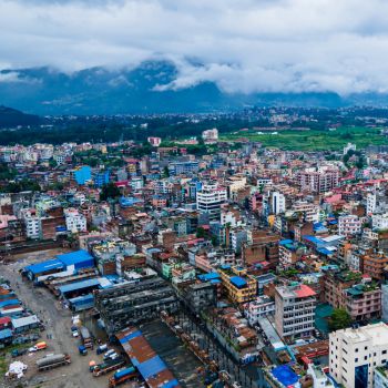 Aerial view of Kathmandu, Nepal, with mountains in the background.