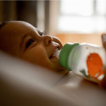A baby feeding through a bottle.