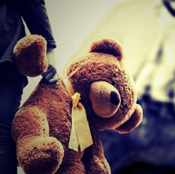 child holding a teddy