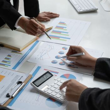 A close up of two businessmen using a calculator.