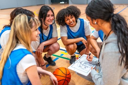 female coach explaining tactics to her team