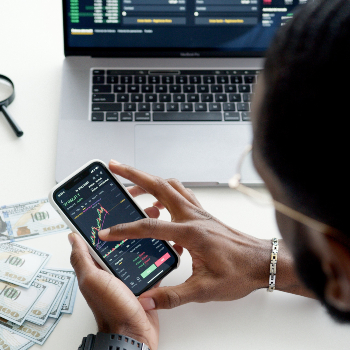 man looking at mobile phone showing stock market