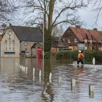 Flooding on the street in North Yorkshire, United Kingdom. with a person walking.