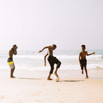 Children playing football on a beach