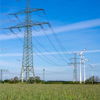 Overhead power lines and wind turbines.
