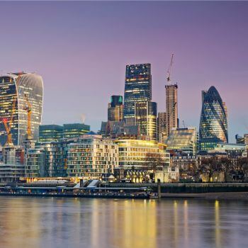 London skyline at dusk with iconic skyscrapers and Thames River.