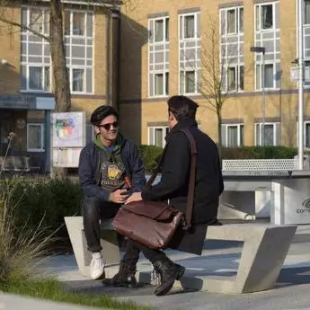 two students chatting on a bench 1