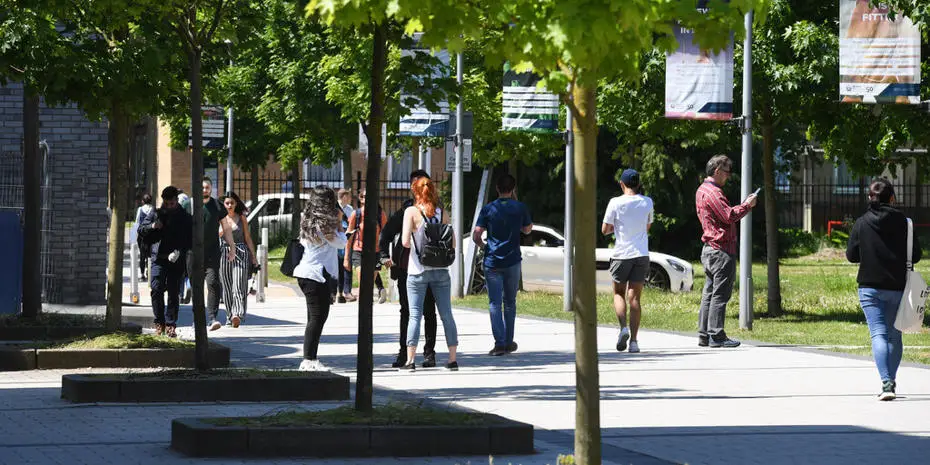 Brunel students walking and chatting on campus concourse