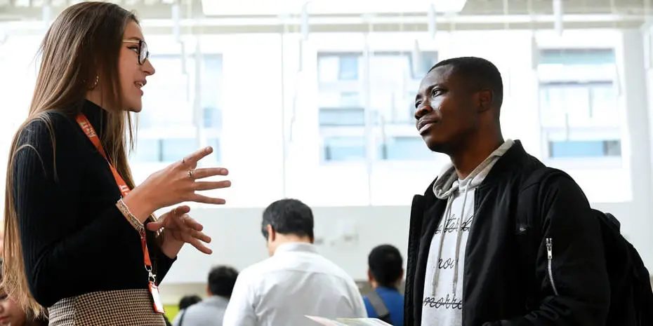 Two people talking at a Postgraduate Careers Fair