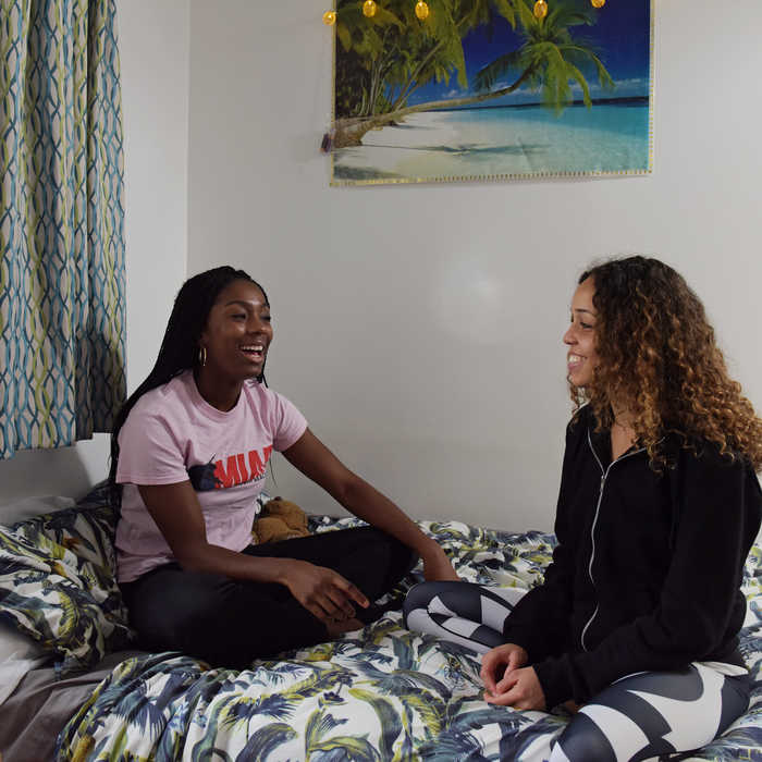 Two students talking in accommodation bedroom