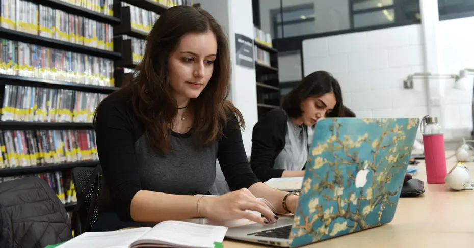 Student working on a laptop in the Library of Brunel University London