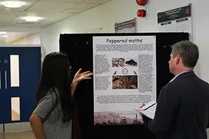 Student explaining poster presentation to lecturer. 