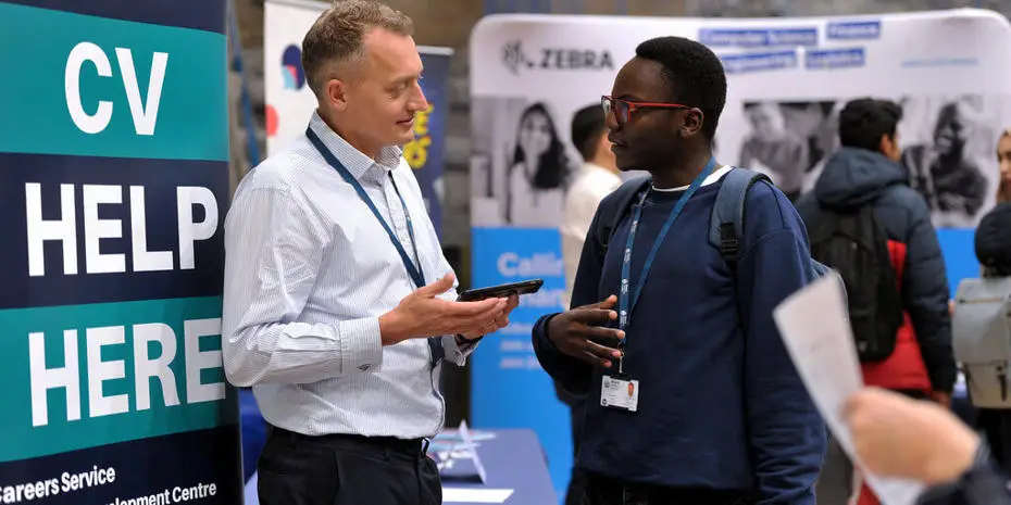 People talking at the Placement and Careers Centre stand at a careers fair