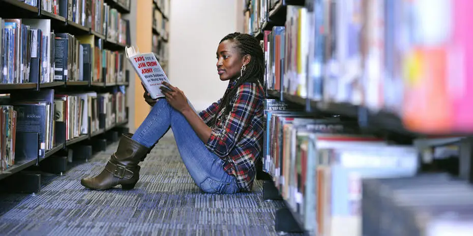 student reading a book in the library