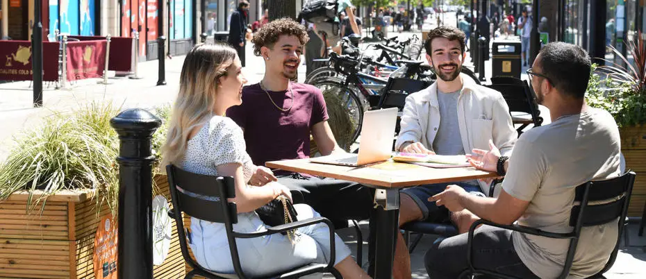 Group of students sitting outside a cafe talking
