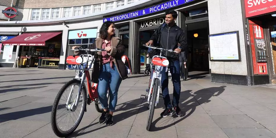 Uxbridge underground station, students walking with Santander bikes in front