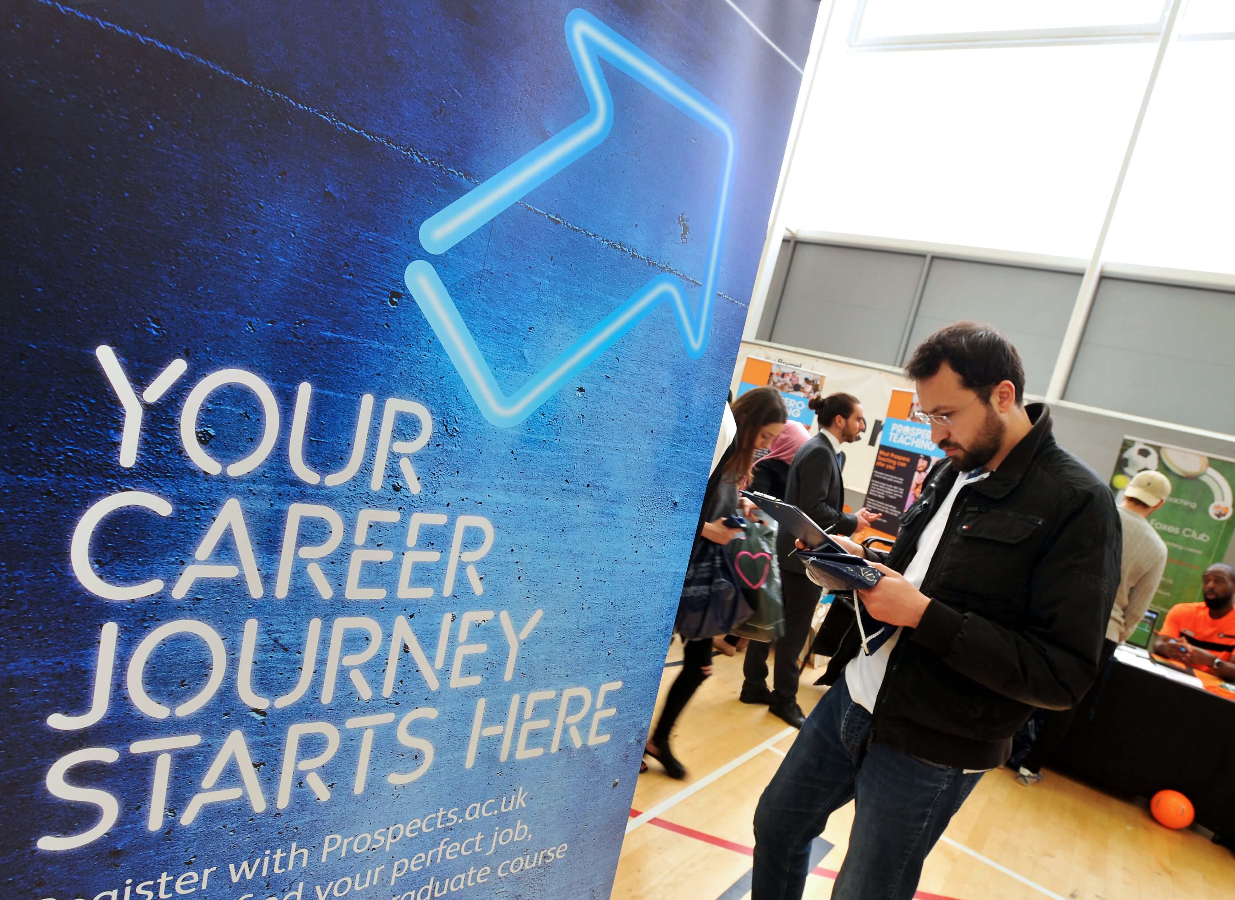 Student standing in front of a careers fair stand