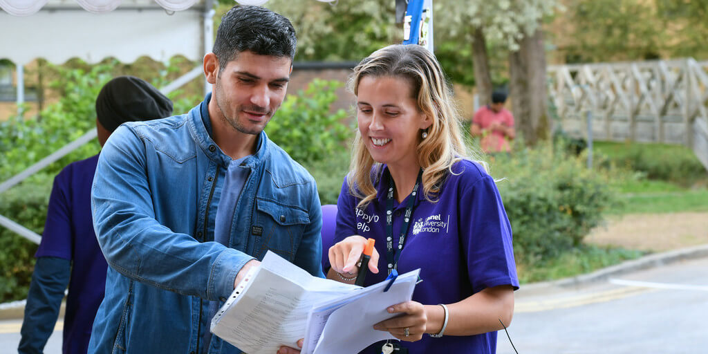 male fresher getting direction from female staff member