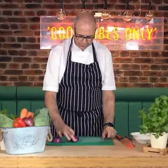 Brunel's Taste Kingdom head chef chopping onion.