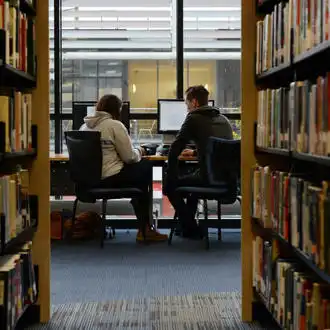 two students studying by a PC in Brunel Library