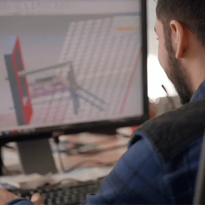 Man working on a 3D design model displayed on a computer screen