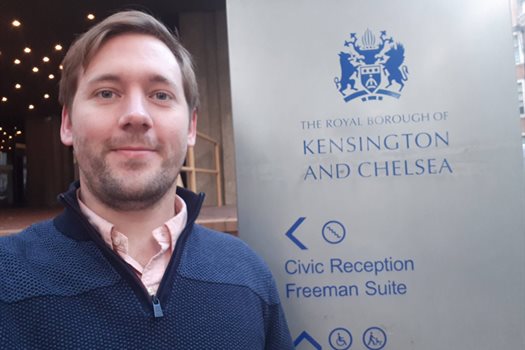 male student in front of a banner