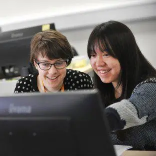 Postgraduate students studying in front of a computer