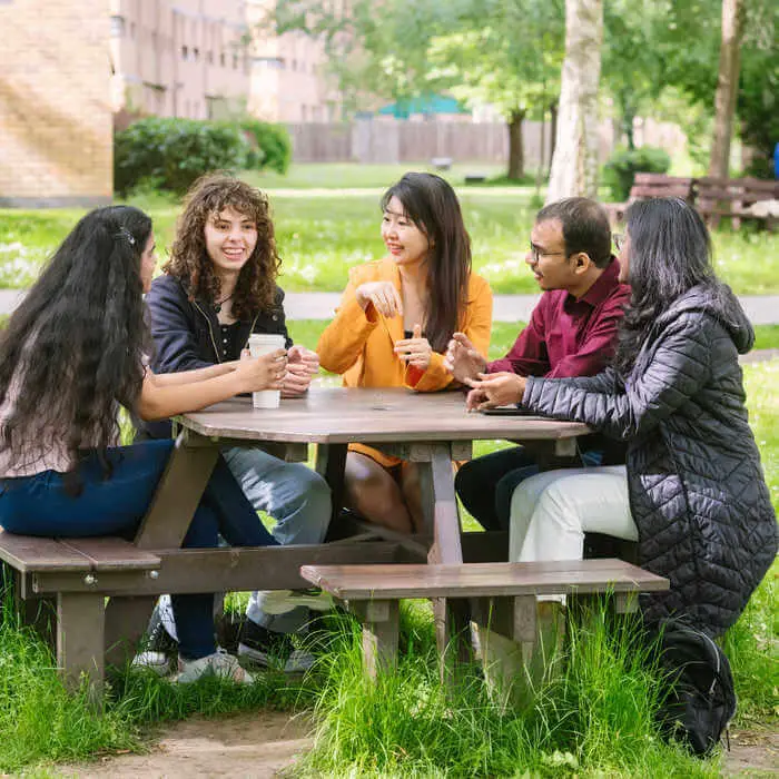 group of students around a table in a park