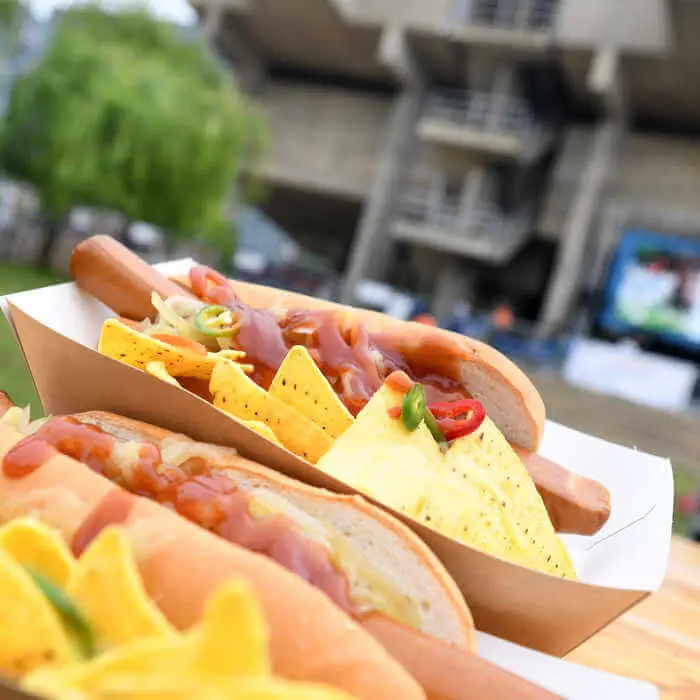 two portions of hot dog meals in front of a building