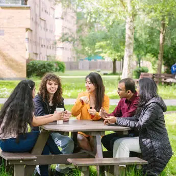 group of students having drinks on a bench