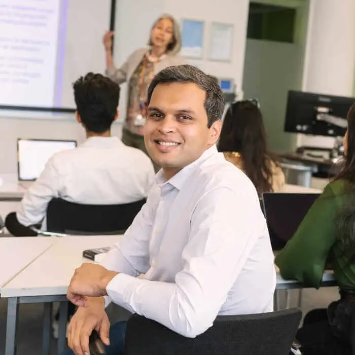 student attending a lecture smiling into the camera