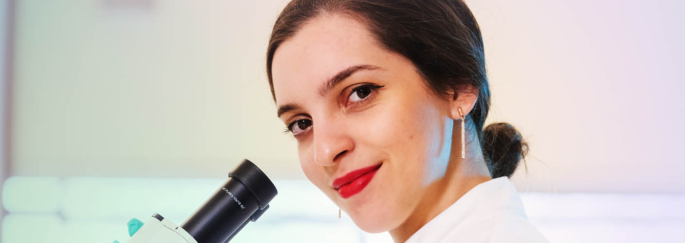 Biomed student using a microscope in the lab