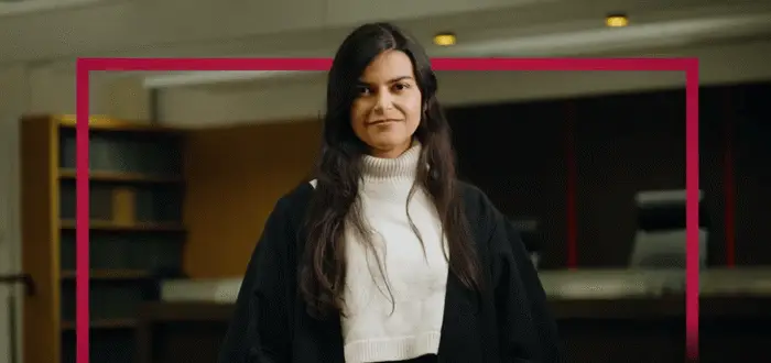 A person in barister clothes stands infront of shelves