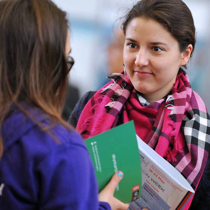 two women chatting at Brunel University's career fair