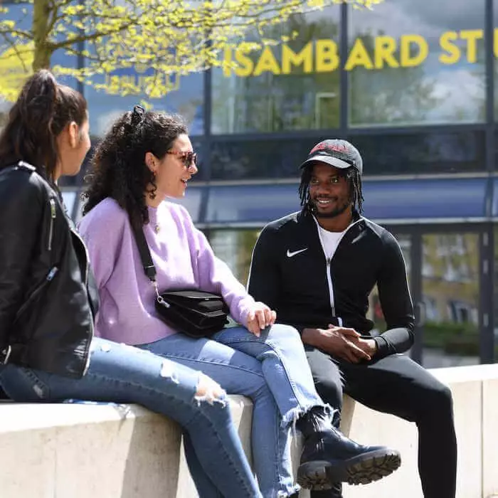 group of students chatting in fromt of Isambard Studio campus building