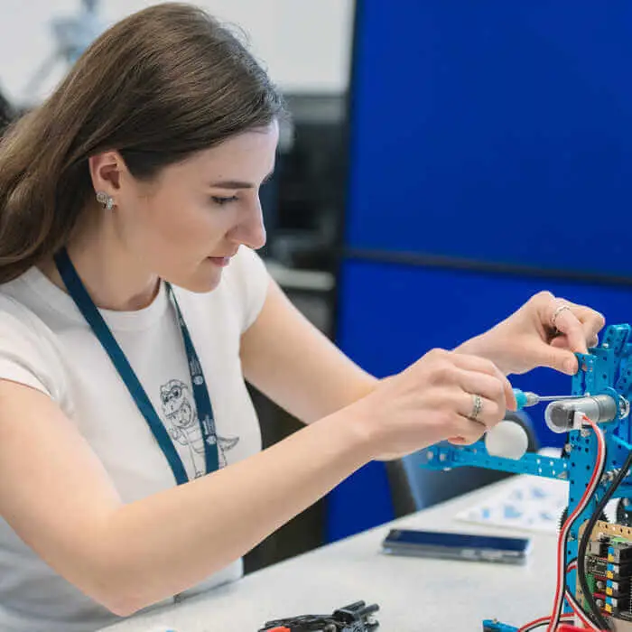 Person assembling electronic components on a stand with tools nearby