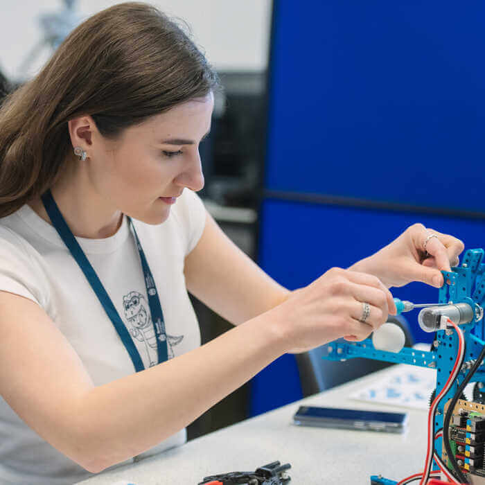 Person assembling electronic components on a stand with tools nearby