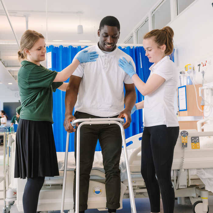 OT students walking with zimmerframe