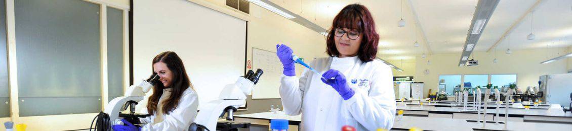 two-brunel-students-in-white-coats-working-in-a-lab-with-various-equipment