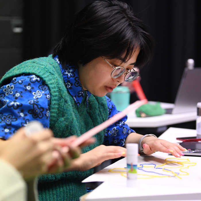 Female student glueing string to the page