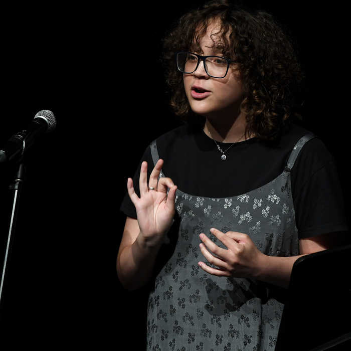 Female creative writing student speaking to an audience